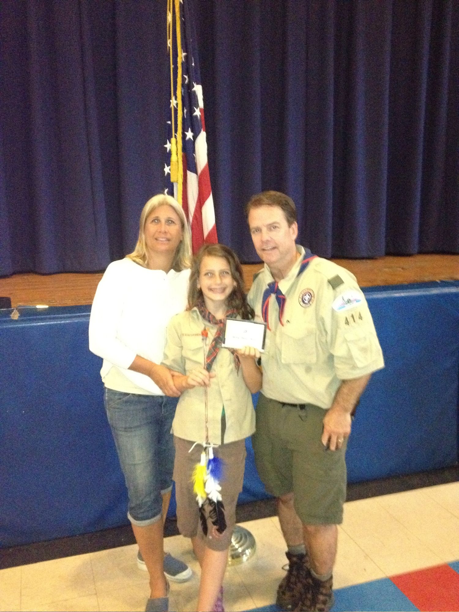 Sydney as a young scout at an award ceremony with two adults