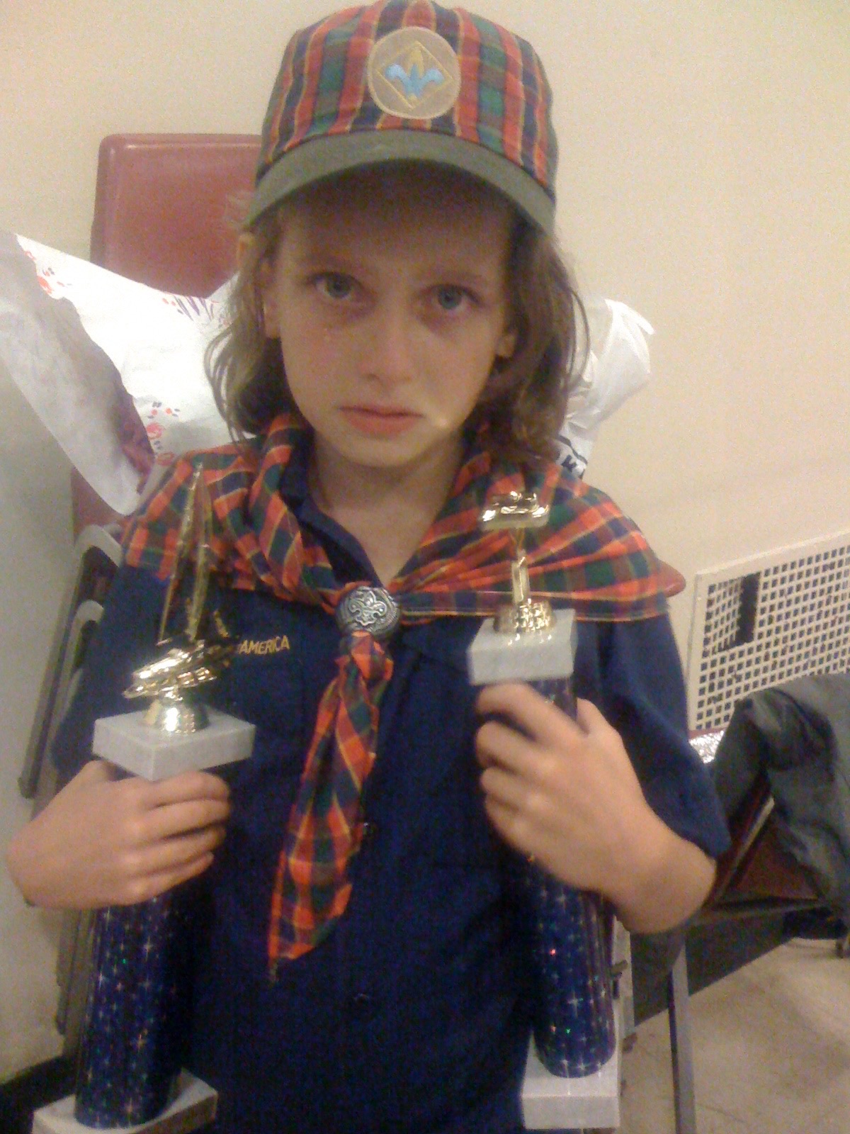 Young Sydney in scout uniform holding two trophies
